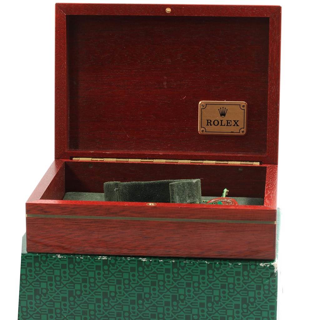 The image shows an open wooden Rolex box with an empty watch holder inside, likely for a Submariner model watch.