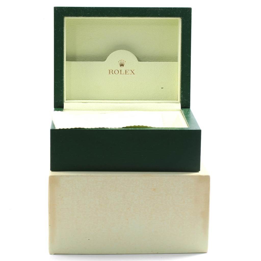 The image shows an open green and cream-colored Rolex watch box, likely for the Submariner model.