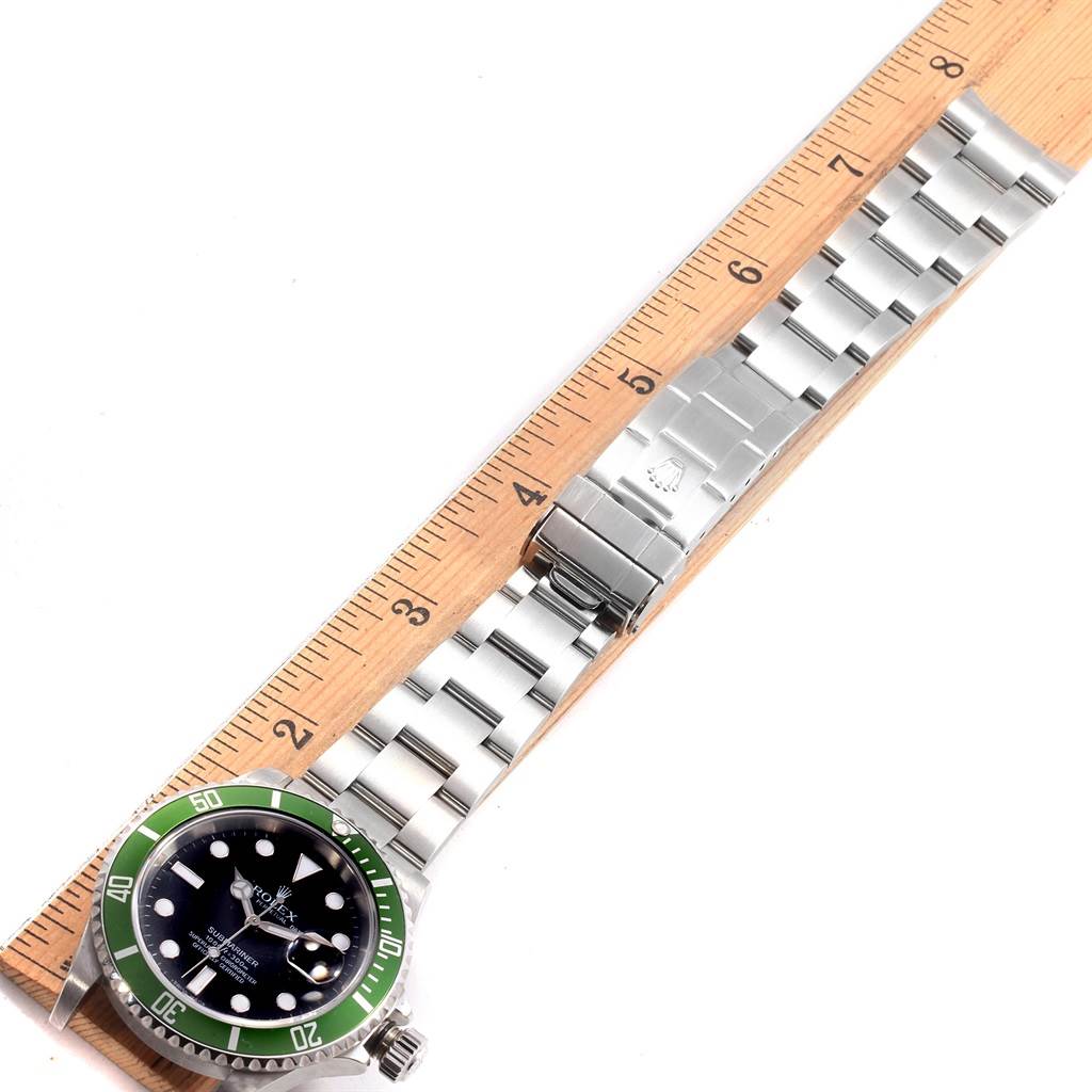 The image shows a Rolex Submariner 16610LV Men's Stainless Steel Black Dial 16610LV Men's Stainless Steel Black Dial watch from an overhead angle, displaying the face, bezel, bracelet, and clasp against a ruler.
