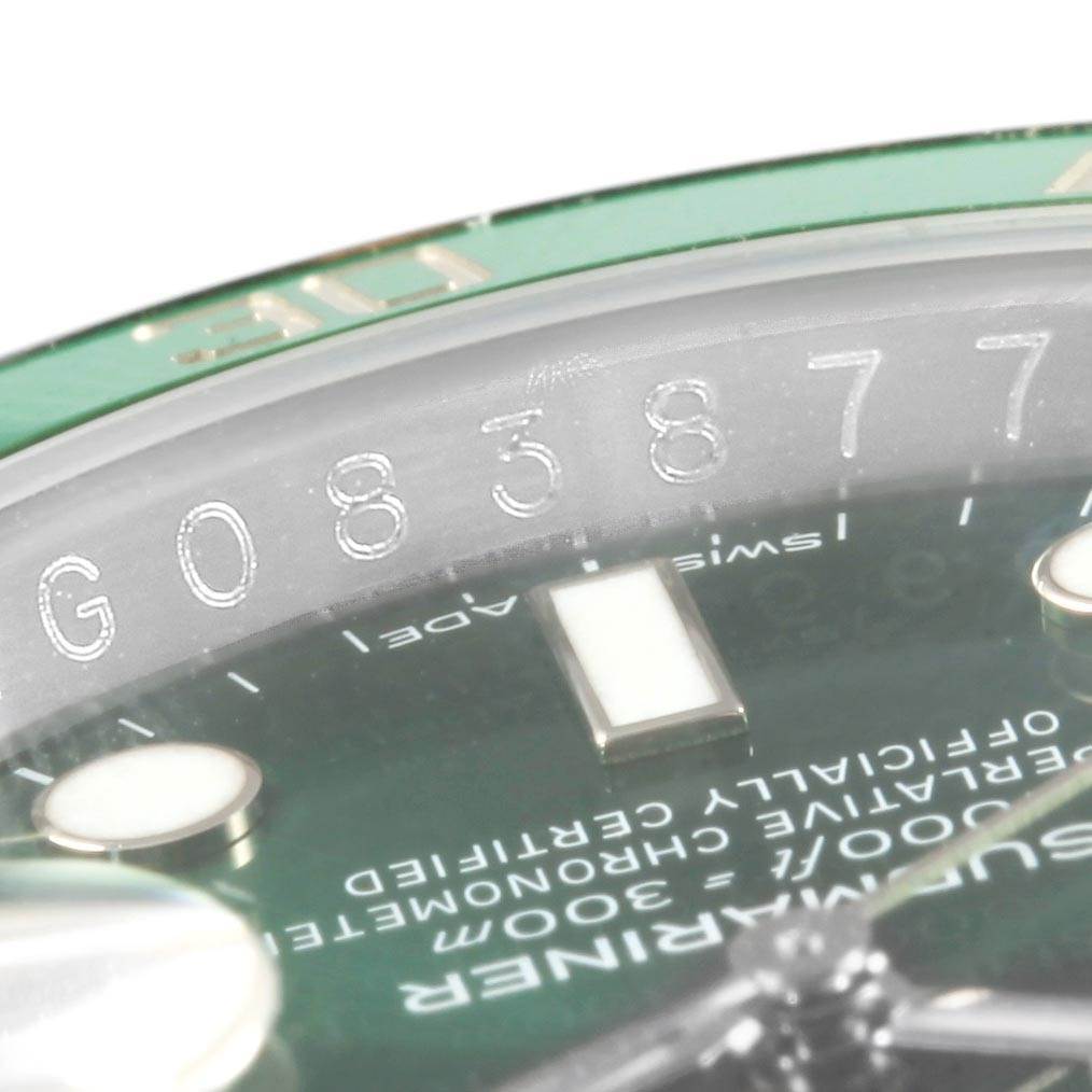 This close-up view of a Rolex Submariner 116610LV Men's Stainless Steel Green Dial 116610LV Men's Stainless Steel Green Dial showcases the bezel, serial number, and part of the dial.