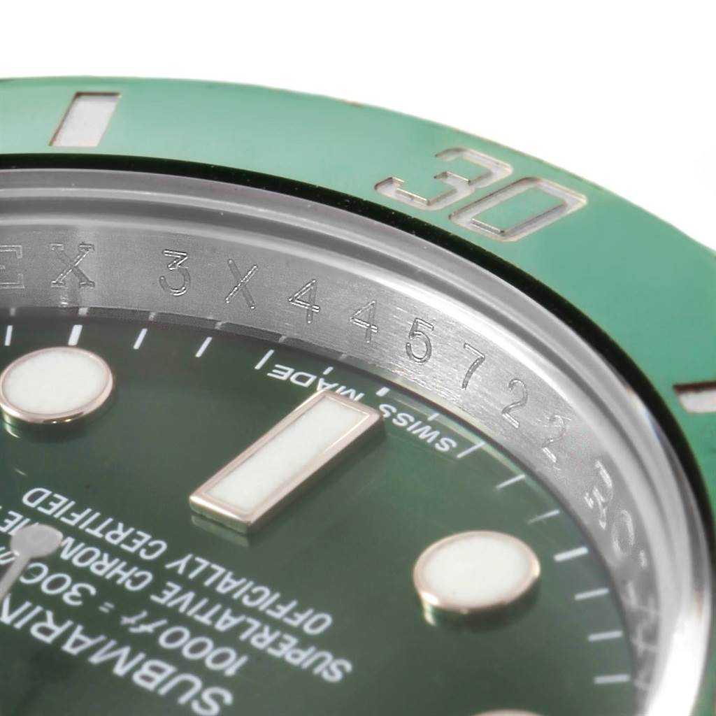 Close-up of the Rolex Submariner 116610LV Men's Stainless Steel Green Dial 116610LV Men's Stainless Steel Green Dial watch showing part of the green bezel, dial, and a portion of the rehaut with engraved serial numbers.