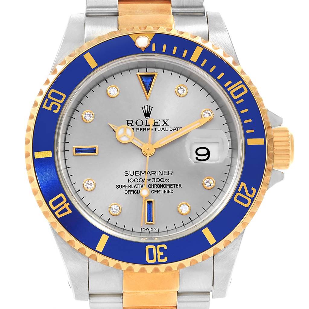 The image shows a front-facing view of a Rolex Submariner 16613 Men's Steel and Gold (two tone) Grey Dial 16613 Men's Steel and Gold (two tone) Grey Dial watch, highlighting its blue and gold bezel, silver dial, and two-tone bracelet.
