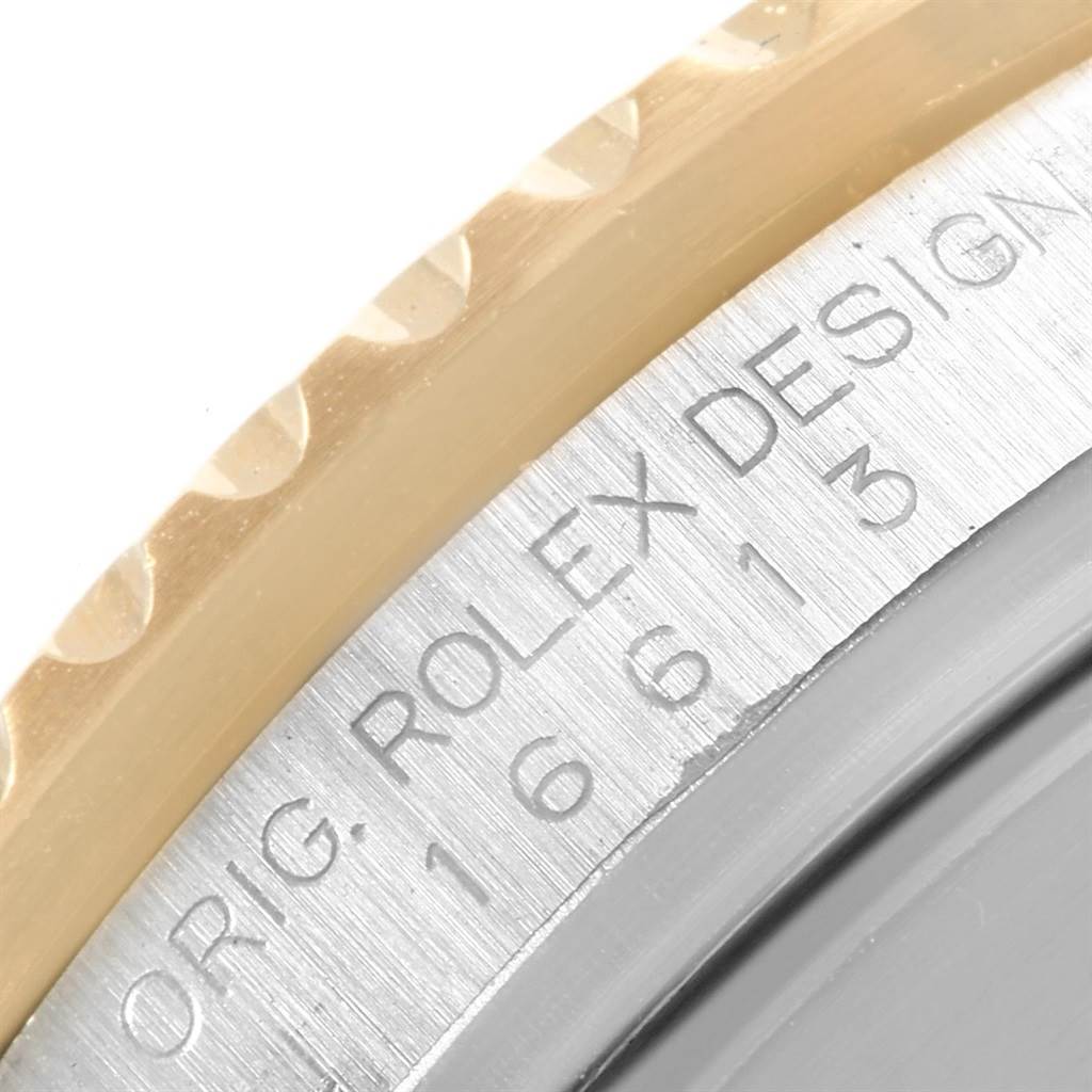 The image shows a close-up of the edge of the bezel and the engraved case back of a Rolex Submariner 16613 Men's Steel and Gold (two tone) Champagne Dial 16613 Men's Steel and Gold (two tone) Champagne Dial model.