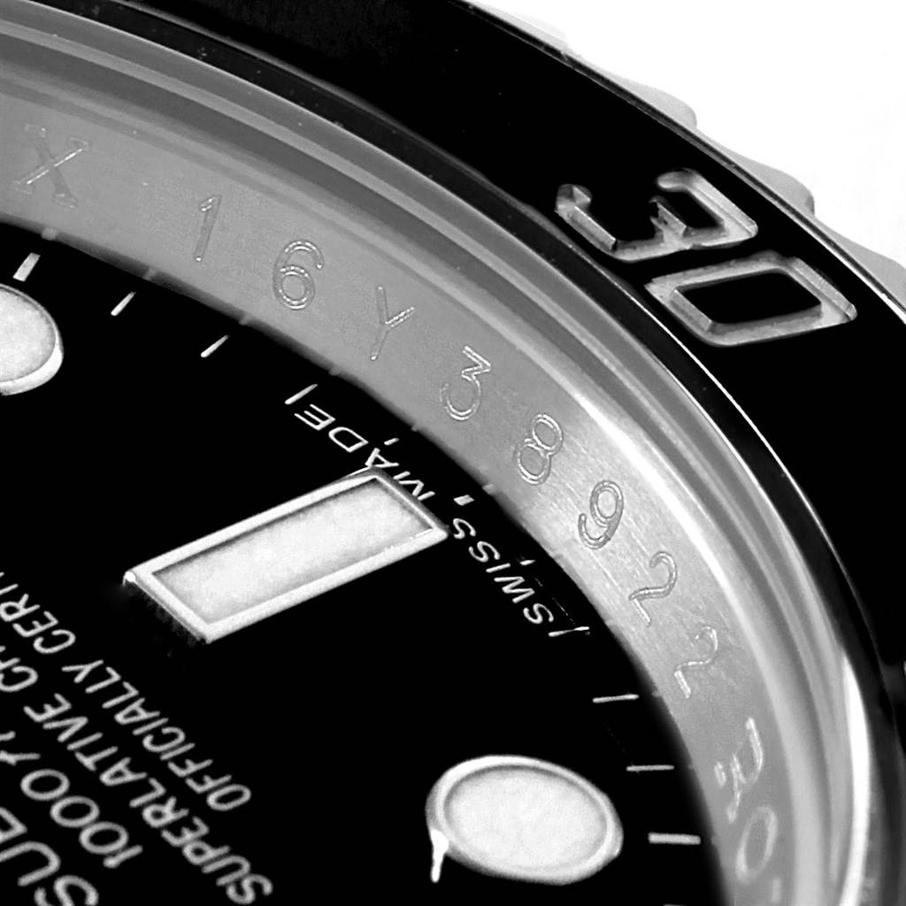 The image shows a close-up of the bezel lettering and part of the dial and hands of a Rolex Submariner 114060 Men's Stainless Steel Black Dial 114060 Men's Stainless Steel Black Dial watch.
