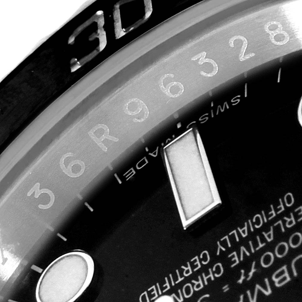 This close-up angle of the Rolex Submariner 114060 Men's Stainless Steel Black Dial 114060 Men's Stainless Steel Black Dial watch shows a partial view of the dial, minute markers, lettering, and part of the bezel.
