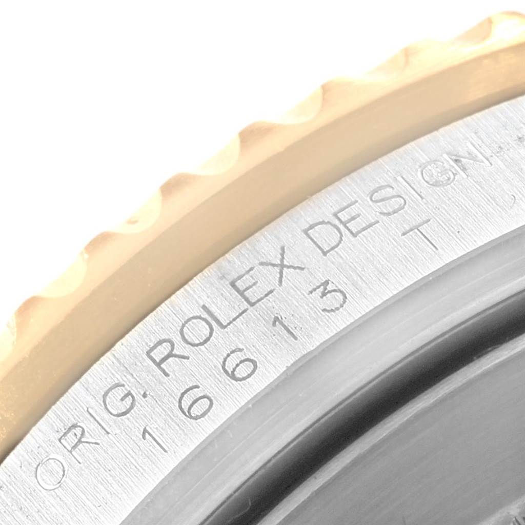 The image shows a close-up of the bezel and engraved edge of a Rolex Submariner 16613 Men's Steel and Gold (two tone) Champagne Dial 16613 Men's Steel and Gold (two tone) Champagne Dial watch.