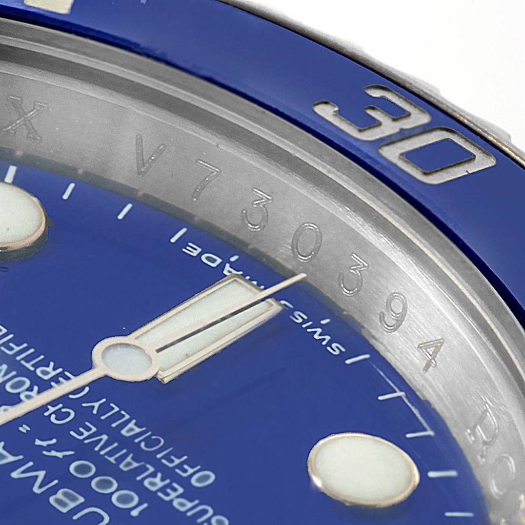 The image shows a close-up of the Rolex Submariner 116619 Men's White Gold Blue Dial 116619 Men's White Gold Blue Dial watch, focusing on the bezel, dial, and part of the serial number.
