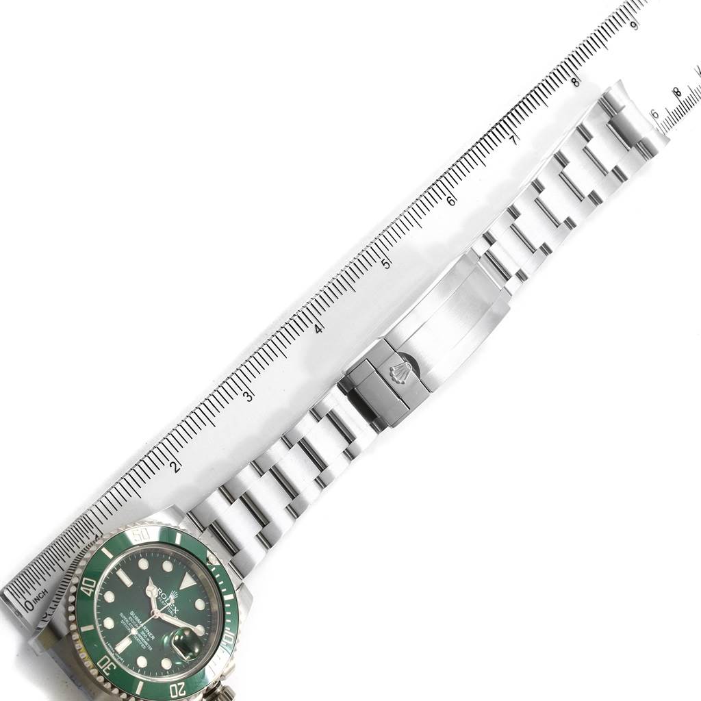 This image shows a top-down view of a Rolex Submariner 116610LV Men's Stainless Steel Green Dial 116610LV Men's Stainless Steel Green Dial watch with a green bezel, accompanied by a ruler for scale.