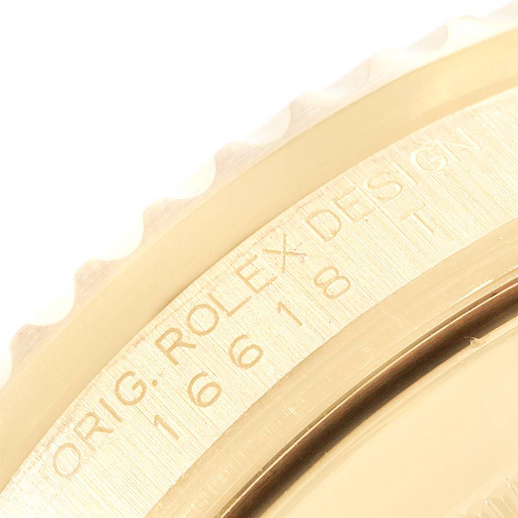 This close-up image shows part of the gold bezel and engravings on the side of a Rolex Submariner 16618 Men's Yellow Gold Black Dial 16618 Men's Yellow Gold Black Dial watch.