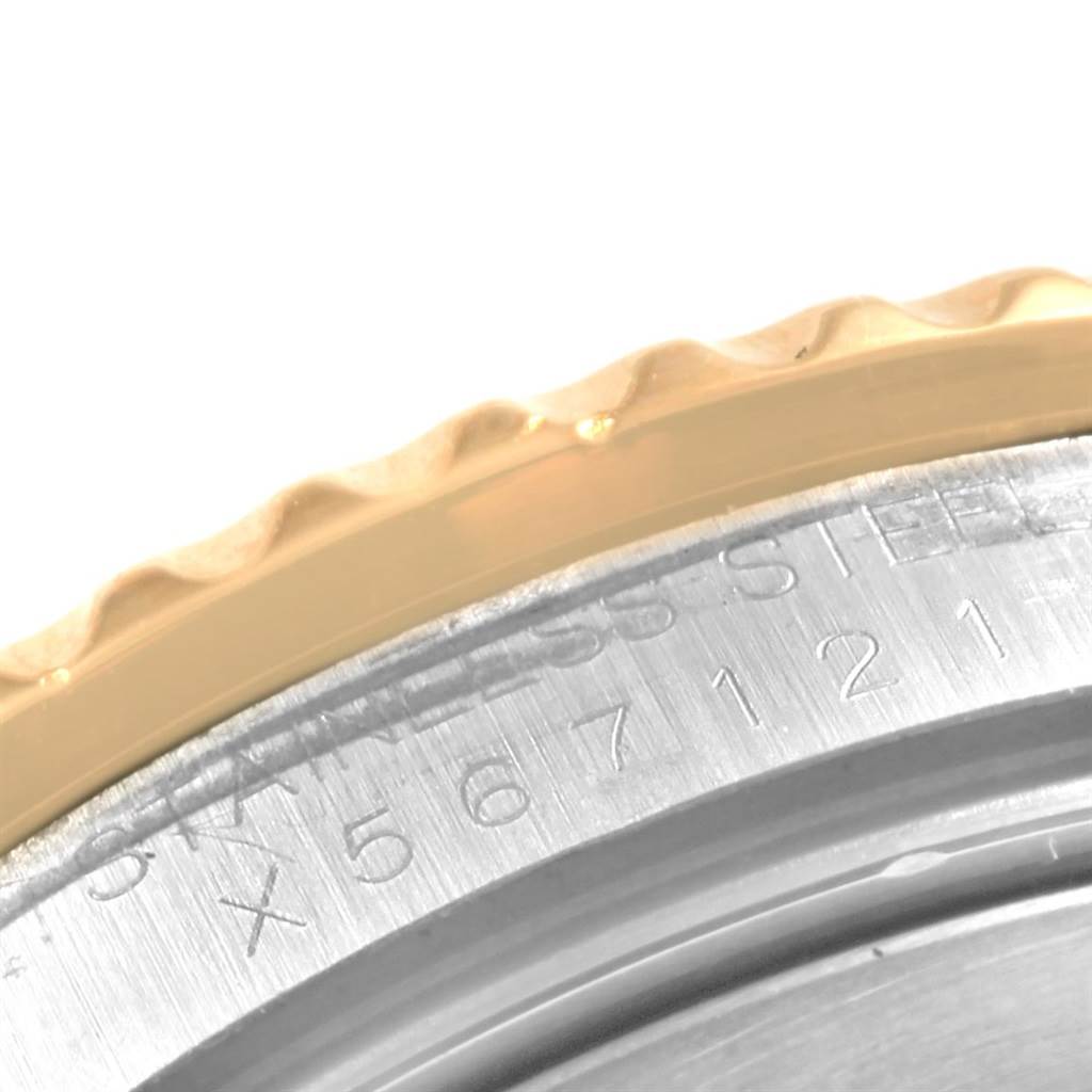 This close-up image of the Rolex Submariner 16613 Men's Steel and Gold (two tone) Black Dial 16613 Men's Steel and Gold (two tone) Black Dial features the edge of the bezel and part of the case back with engraved text.