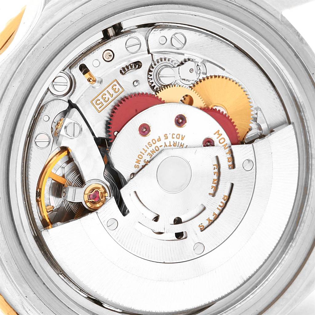This image shows the intricate internal mechanisms and gears of a Rolex Submariner 16613 Men's Steel and Gold (two tone) Blue Dial 16613 Men's Steel and Gold (two tone) Blue Dial watch from a close-up, top-down angle.