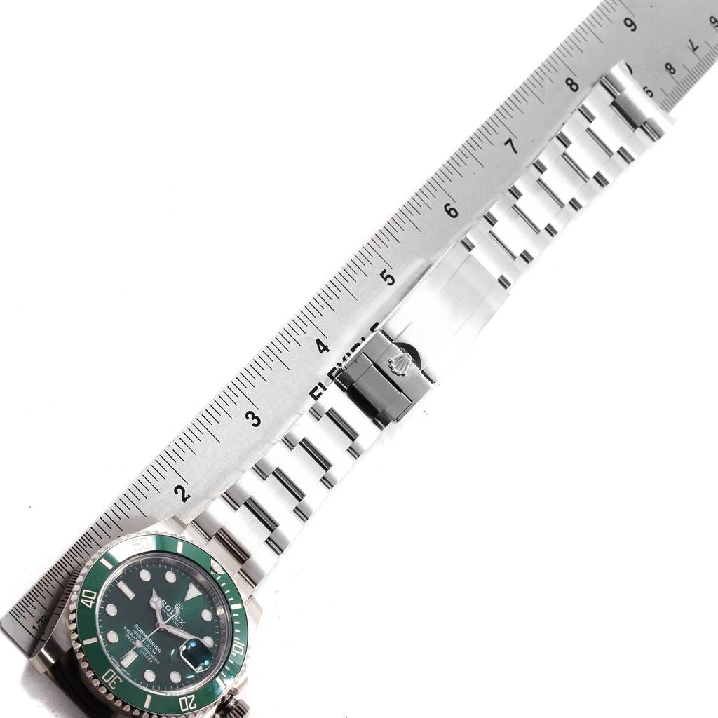 The image shows a Rolex Submariner 116610LV Men
s Stainless Steel Green Dial 116610LV Men
s Stainless Steel Green Dial watch laid flat with its band extended alongside a measuring ruler.
