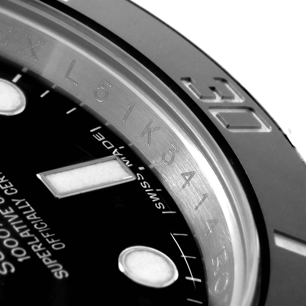 This close-up image of a Rolex Submariner 114060 Men's Stainless Steel Black Dial 114060 Men's Stainless Steel Black Dial watch shows the bezel, part of the dial, and the rehaut with engraved serial numbers.