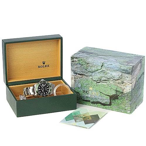 The image shows a Rolex Submariner 16610LV Men's Stainless Steel Black Dial 16610LV Men's Stainless Steel Black Dial watch in an open green and wood Rolex box, alongside a closed box and pamphlets.
