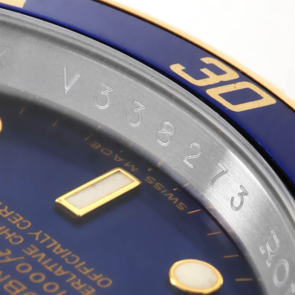 Close-up of a Rolex Submariner 16613 Men's Steel and Gold (two tone) Blue Dial 16613 Men's Steel and Gold (two tone) Blue Dial watch showing part of the dial, bezel, and minute markers.