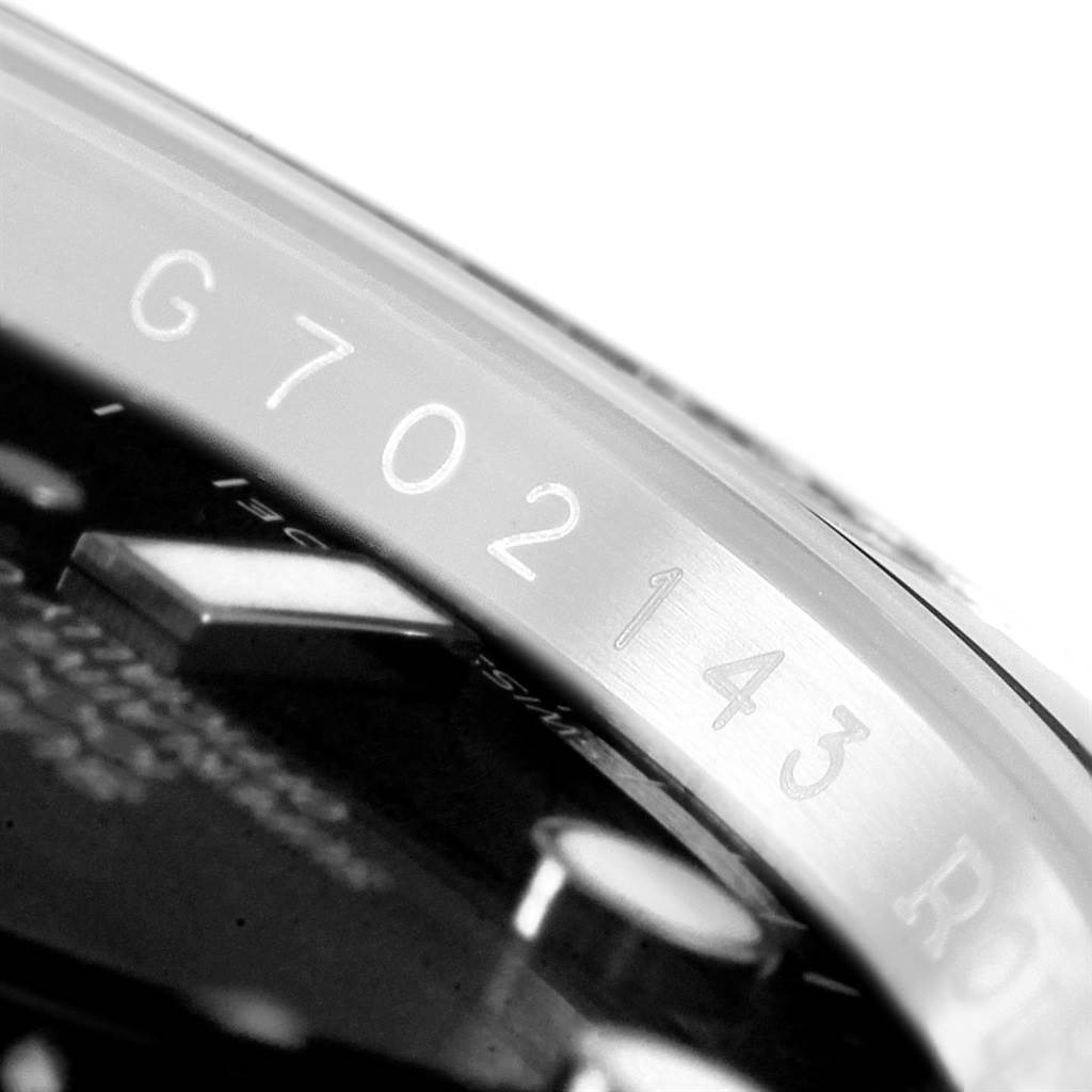 This image shows a close-up of the side of the bezel and dial of a Rolex Submariner 116610 Men's Stainless Steel Black Dial 116610 Men's Stainless Steel Black Dial, highlighting the watch's serial number and part of the Rolex logo.