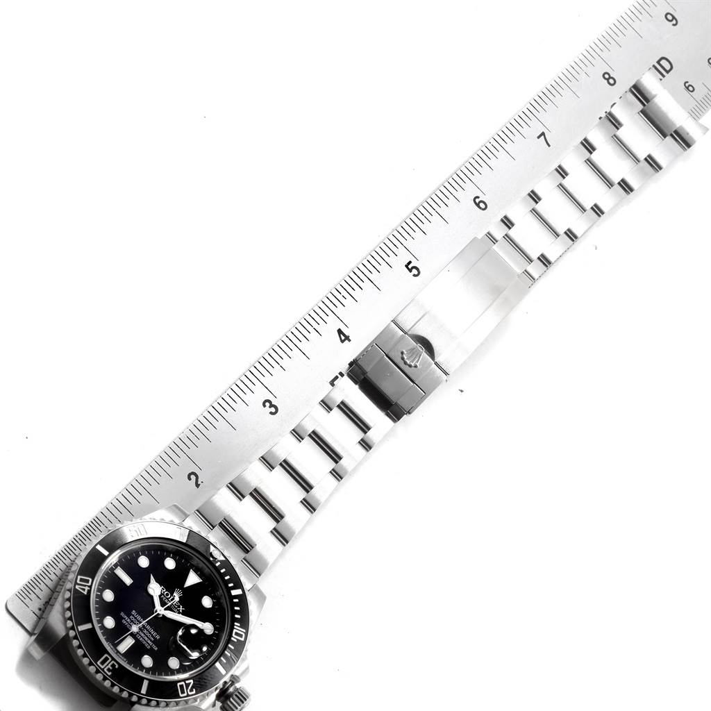 The image shows a top view of a Rolex Submariner 116610 Men's Stainless Steel Black Dial 116610 Men's Stainless Steel Black Dial watch with its bracelet placed next to a ruler for measurement.