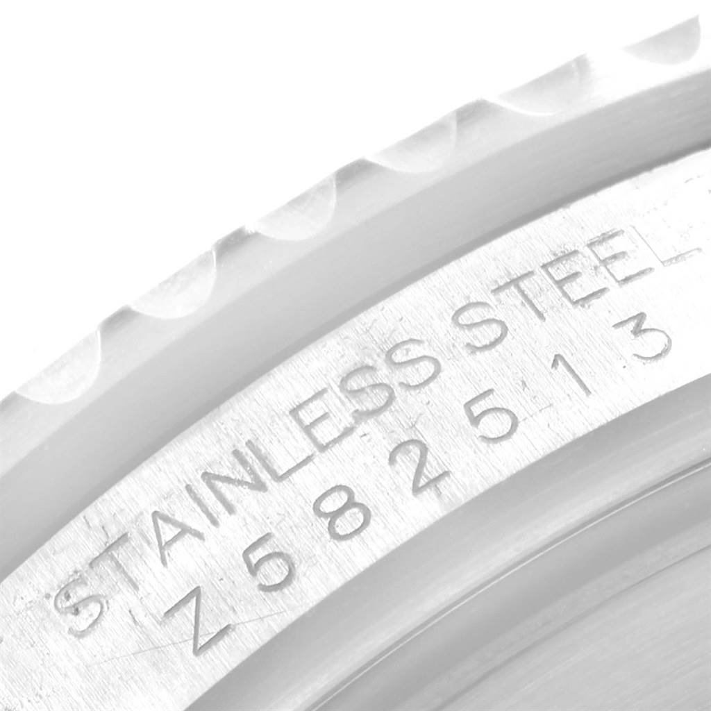 This close-up image shows the engraved serial number and the stainless steel text on the bezel of a Rolex Submariner 16610 Men's Stainless Steel Black Dial 16610 Men's Stainless Steel Black Dial.