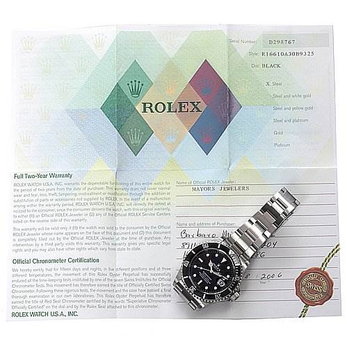 This image shows a Rolex Submariner 16610 Men's Stainless Steel Black Dial 16610 Men's Stainless Steel Black Dial watch with its metal bracelet laid flat, alongside warranty papers and documentation.
