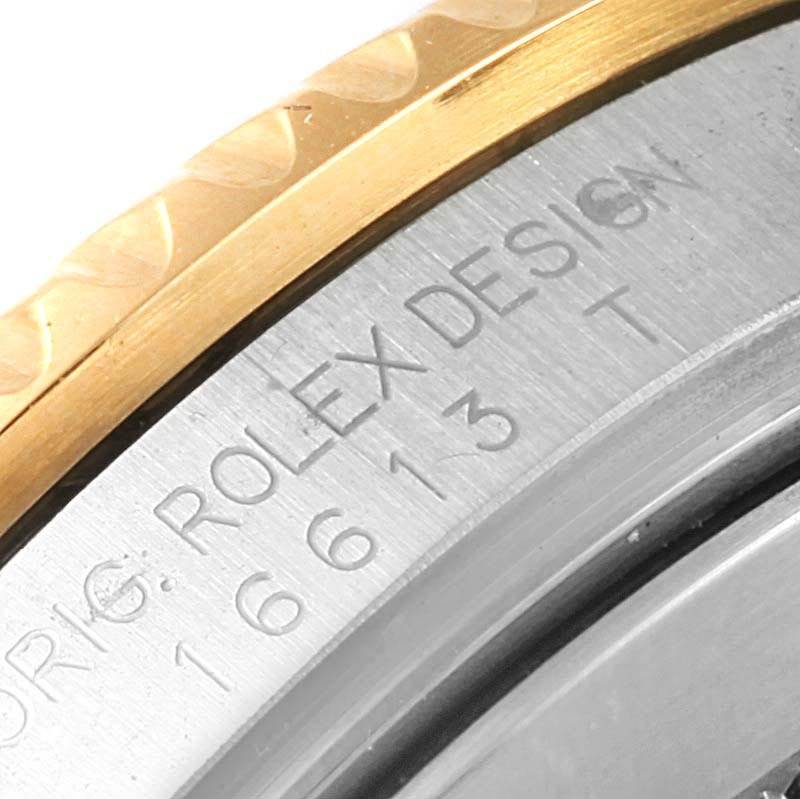 This close-up image shows the text engraving and part of the bezel on a Rolex Submariner 16613 Men's Steel and Gold (two tone) Blue Dial 16613 Men's Steel and Gold (two tone) Blue Dial watch.
