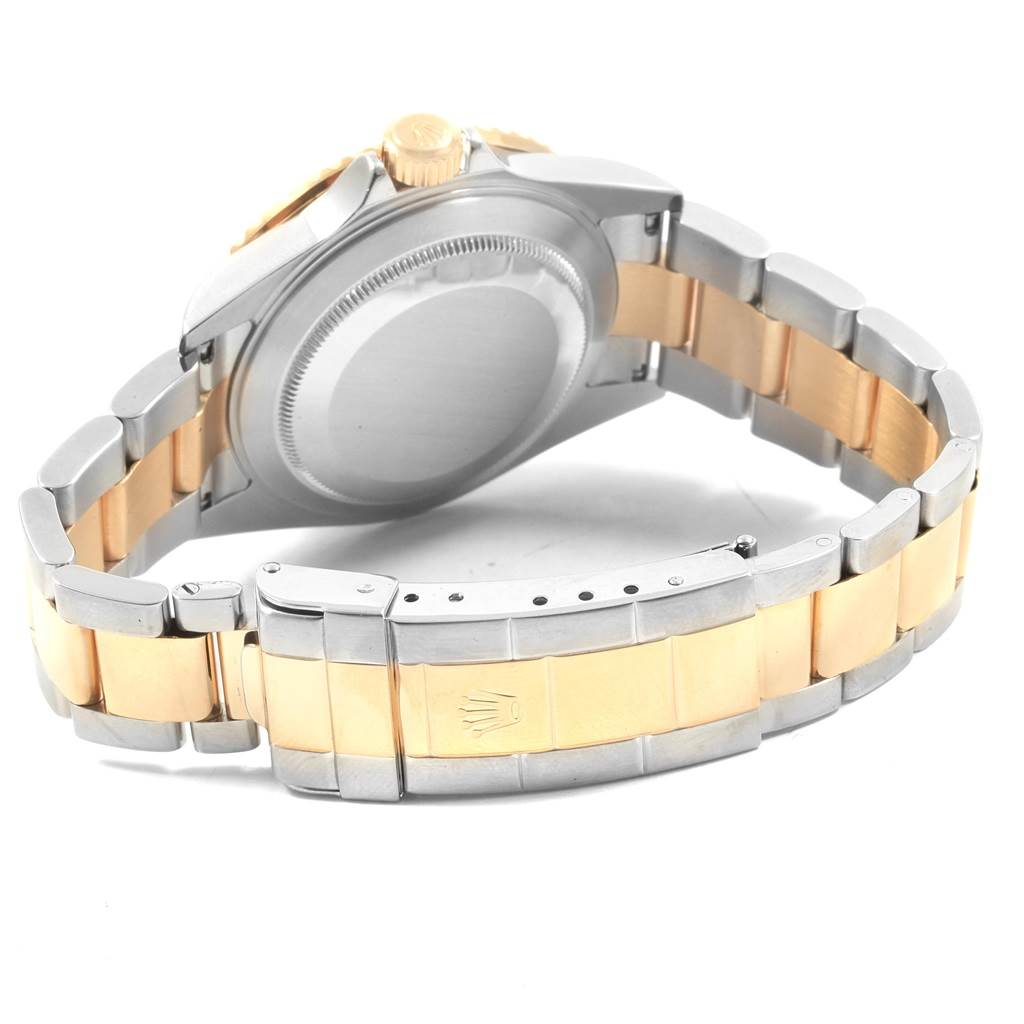 This image shows the back case, crown, and two-tone bracelet of a Rolex Submariner 16613 Men's Steel and Gold (two tone) Blue Dial 16613 Men's Steel and Gold (two tone) Blue Dial model watch.