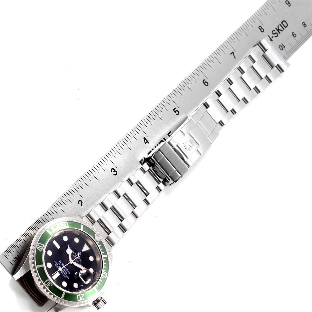 The image shows a Rolex Submariner 16610LV Men's Stainless Steel Black Dial 16610LV Men's Stainless Steel Black Dial watch from a top-down angle, highlighting the face, bezel, bracelet, and clasp with a ruler for scale.