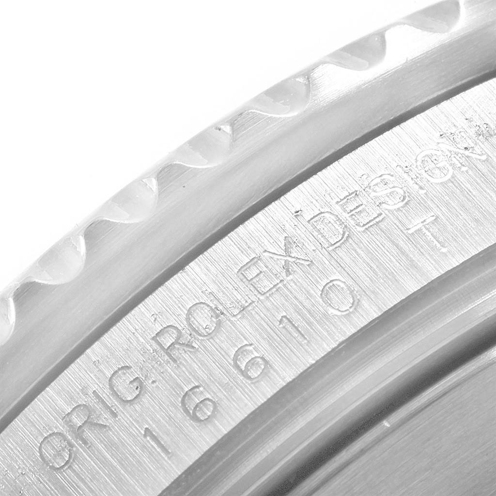 This close-up image of the Rolex Submariner 16610 Men's Stainless Steel Black Dial 16610 Men's Stainless Steel Black Dial watch shows the engraved text and a part of the bezel.