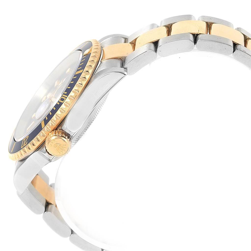 The image shows a side view of the Rolex Submariner 16613 Men's Steel and Gold (two tone) Blue Dial 16613 Men's Steel and Gold (two tone) Blue Dial, highlighting the crown, bezel, and two-tone bracelet.