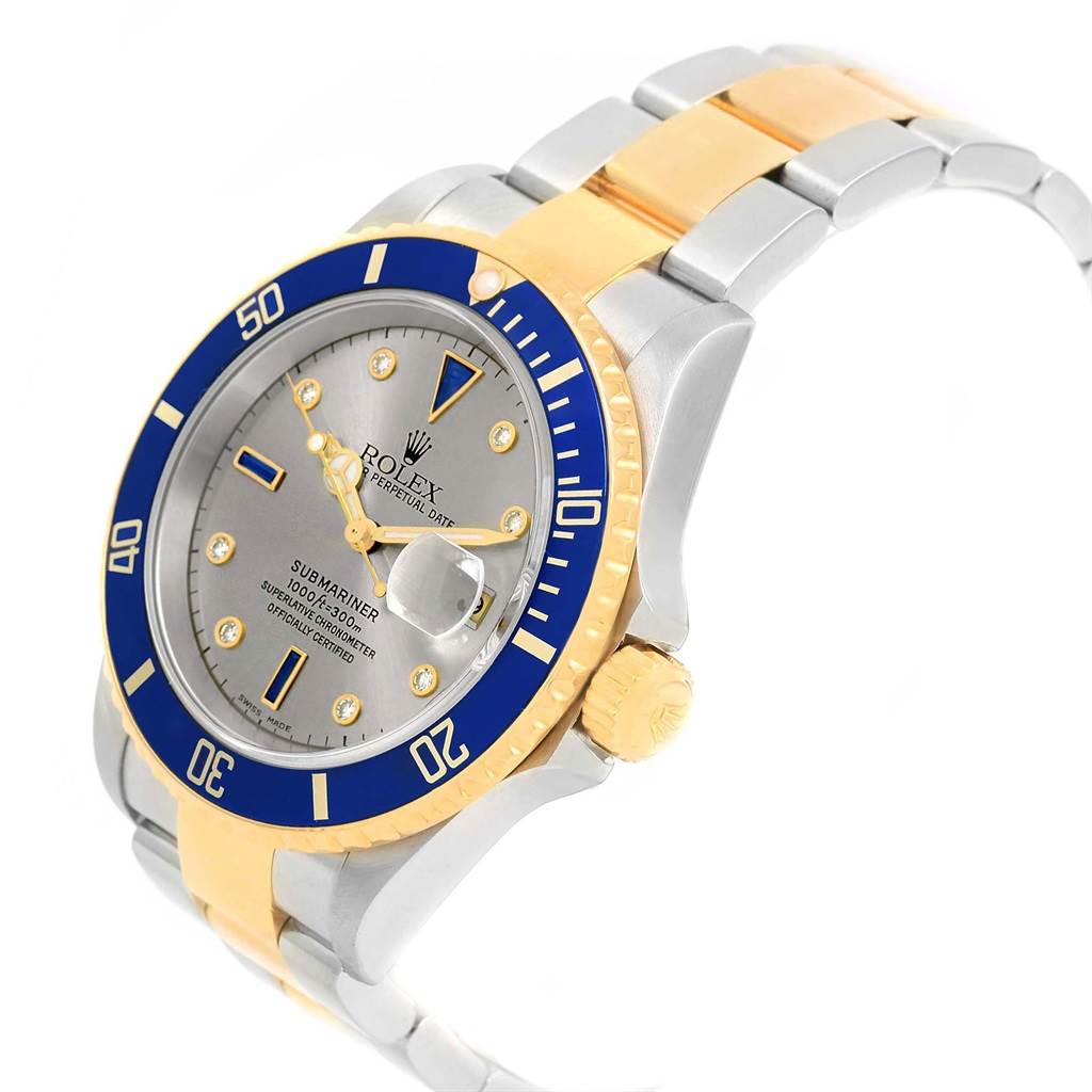 The Rolex Submariner 16613 Men's Steel and Gold (two tone) Grey Dial 16613 Men's Steel and Gold (two tone) Grey Dial watch is shown at a slight angle, highlighting its blue and gold bezel, gray dial, and two-tone bracelet.