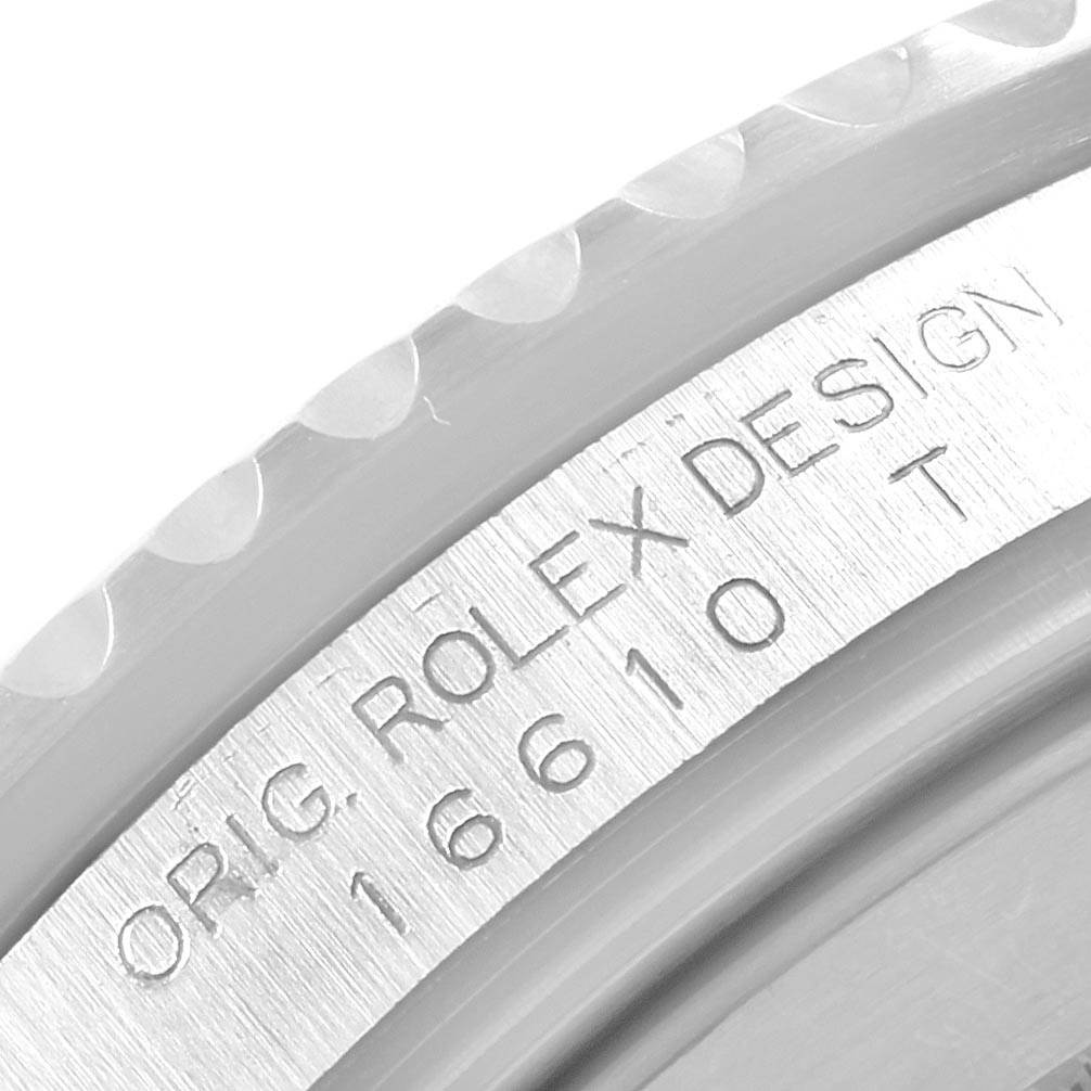 This close-up image shows the side of a Rolex Submariner 16610 Men's Stainless Steel Black Dial 16610 Men's Stainless Steel Black Dial model, displaying the engraving "ORIG. ROLEX DESIGN 16610 T."