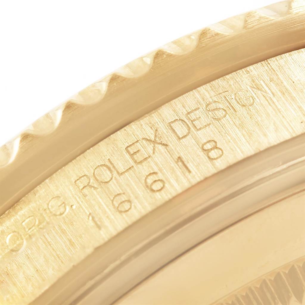 This close-up image shows the side engraving and bezel of a Rolex Submariner 16618 Men's Yellow Gold Blue Dial 16618 Men's Yellow Gold Blue Dial watch.