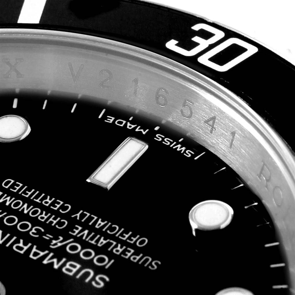 This close-up image of a Rolex Submariner 16610 Men's Stainless Steel Black Dial 16610 Men's Stainless Steel Black Dial watch shows part of the bezel, dial, and detailed engravings.