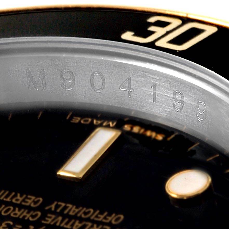 This close-up image of the Rolex Submariner 16613 Men's Steel and Gold (two tone) Black Dial 16613 Men's Steel and Gold (two tone) Black Dial watch shows part of the bezel, serial number, and a section of the dial.
