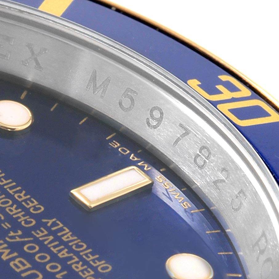This image shows a close-up of the bezel, dial, and part of the serial number engraving on a Rolex Submariner 16613 Men's Steel and Gold (two tone) Blue Dial 16613 Men's Steel and Gold (two tone) Blue Dial watch.