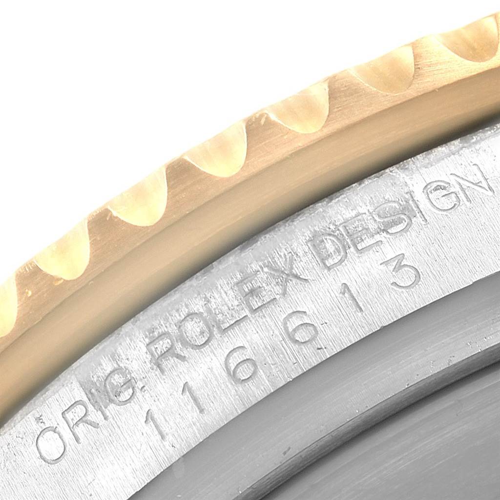 This close-up of the Rolex Submariner 116613 Men's Steel and Gold (two tone) Black Dial 116613 Men's Steel and Gold (two tone) Black Dial watch shows part of the bezel and the engraved model number on the case.