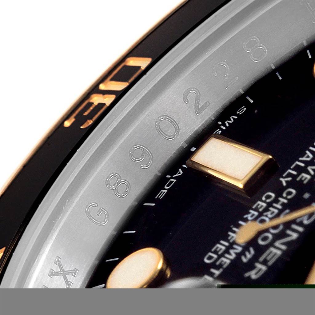 This close-up angle of the Rolex Submariner 116613 Men's Steel and Gold (two tone) Black Dial 116613 Men's Steel and Gold (two tone) Black Dial watch showcases the bezel, serial number, and part of the dial.