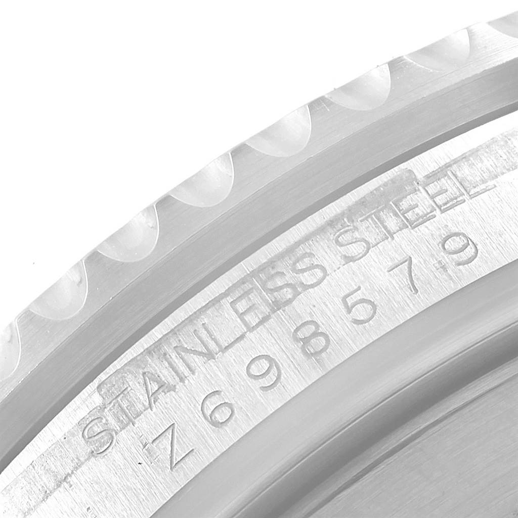 This close-up shot of a Rolex Submariner 16610 Men's Stainless Steel Black Dial 16610 Men's Stainless Steel Black Dial watch shows the edge of the bezel and the engraved stainless steel serial number.