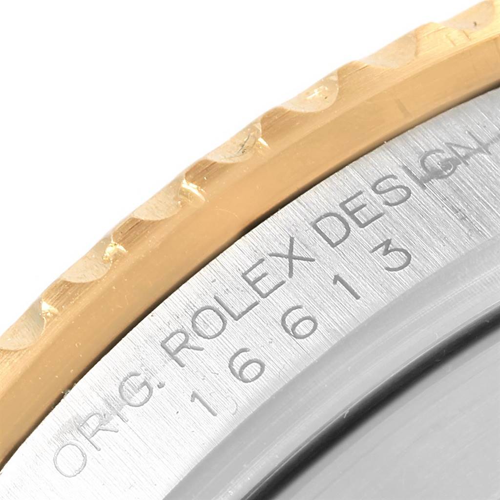 This close-up shows the edge of the bezel and engraved model number of a Rolex Submariner 16613 Men's Steel and Gold (two tone) Blue Dial 16613 Men's Steel and Gold (two tone) Blue Dial watch.