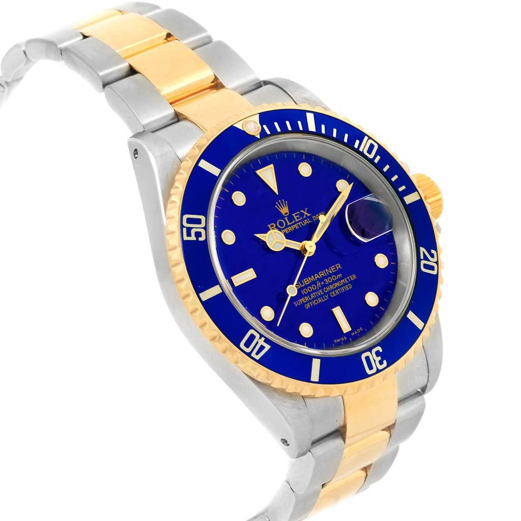 The image shows a Rolex Submariner 16613 Men's Steel and Gold (two tone) Blue Dial 16613 Men's Steel and Gold (two tone) Blue Dial watch at a slight angled view, highlighting its blue dial, bezel, and two-tone bracelet.
