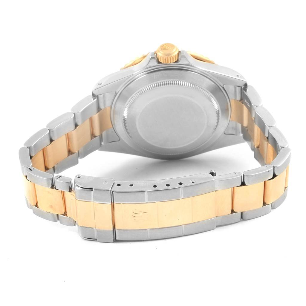 The image shows the back view of a Rolex Submariner 16613 Men's Steel and Gold (two tone) Blue Dial 16613 Men's Steel and Gold (two tone) Blue Dial watch, highlighting its case back, crown, and bracelet clasp.