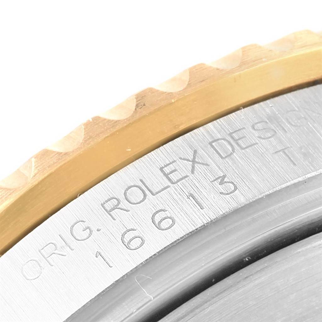 The image shows a close-up of the side engraving and part of the bezel on a Rolex Submariner 16613 Men's Steel and Gold (two tone) Champagne Dial 16613 Men's Steel and Gold (two tone) Champagne Dial watch.