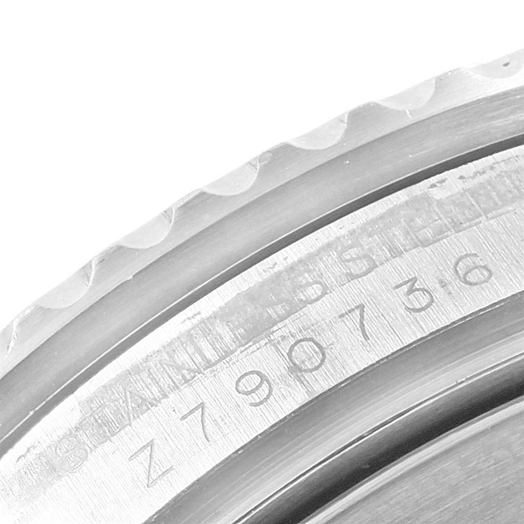 The image shows a close-up of the side engraving and textured bezel of a Rolex Submariner 16610 Men's Stainless Steel Black Dial 16610 Men's Stainless Steel Black Dial watch.