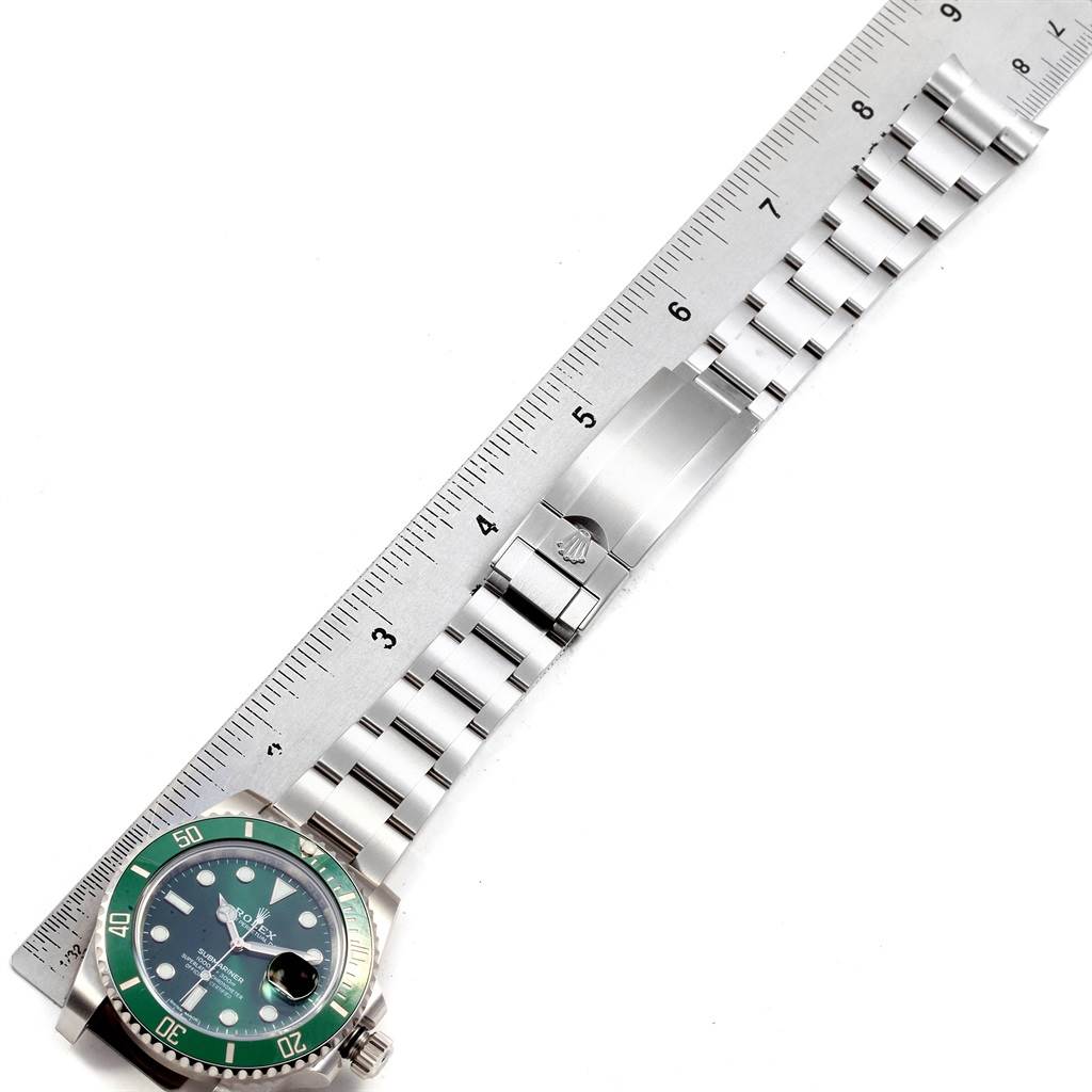 The image shows a Rolex Submariner 116610LV Men
s Stainless Steel Green Dial 116610LV Men
s Stainless Steel Green Dial watch laid flat next to a ruler, displaying the watch face, bracelet, and clasp.