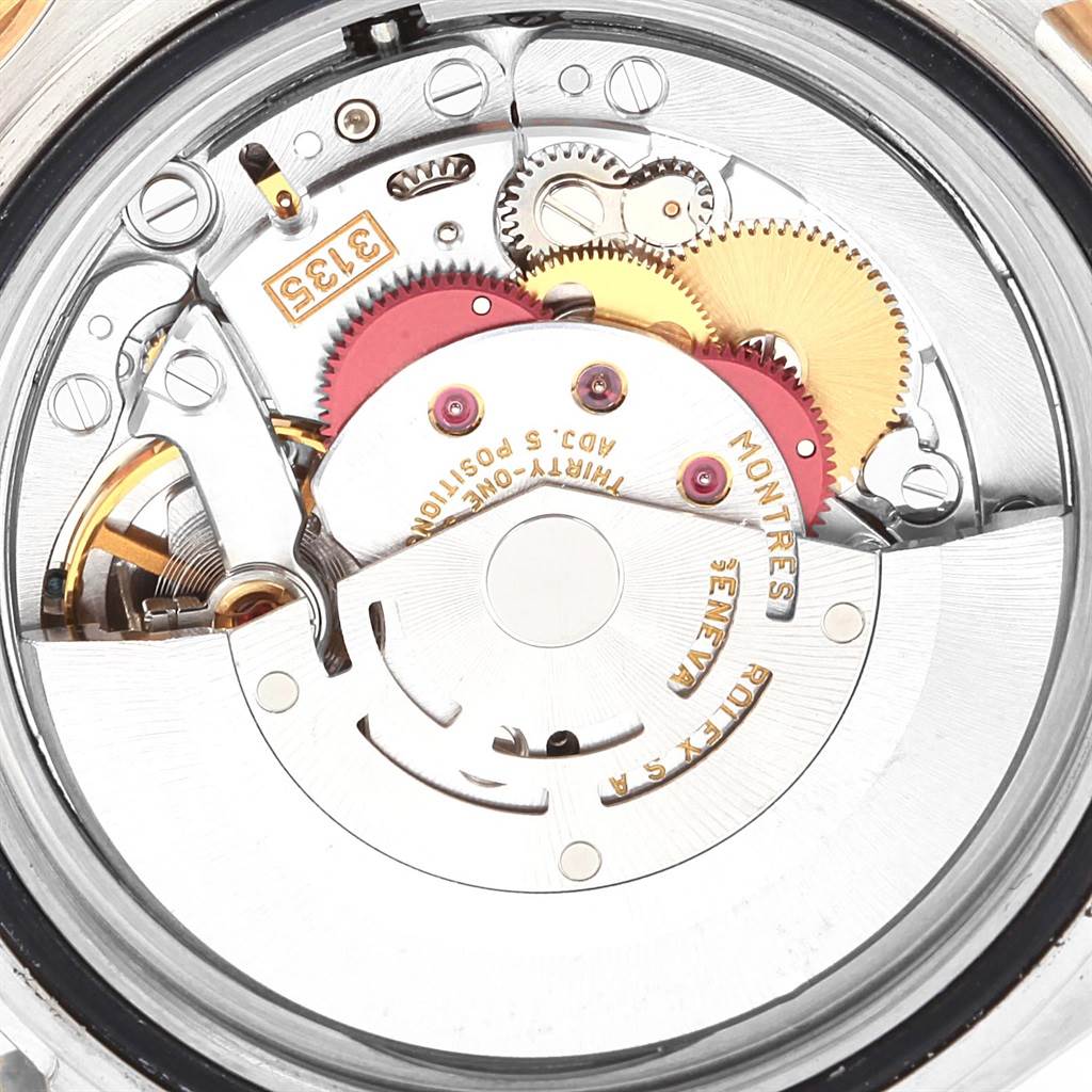 The image shows the internal mechanism of the Rolex Submariner 16613 Men's Steel and Gold (two tone) Grey Dial 16613 Men's Steel and Gold (two tone) Grey Dial watch, highlighting its gears and rotor from the back.