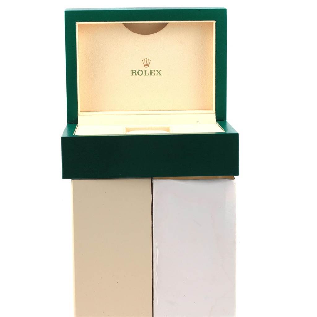 The image shows an open green and beige Rolex watch box, likely for a Submariner model, with the Rolex logo inside the lid.