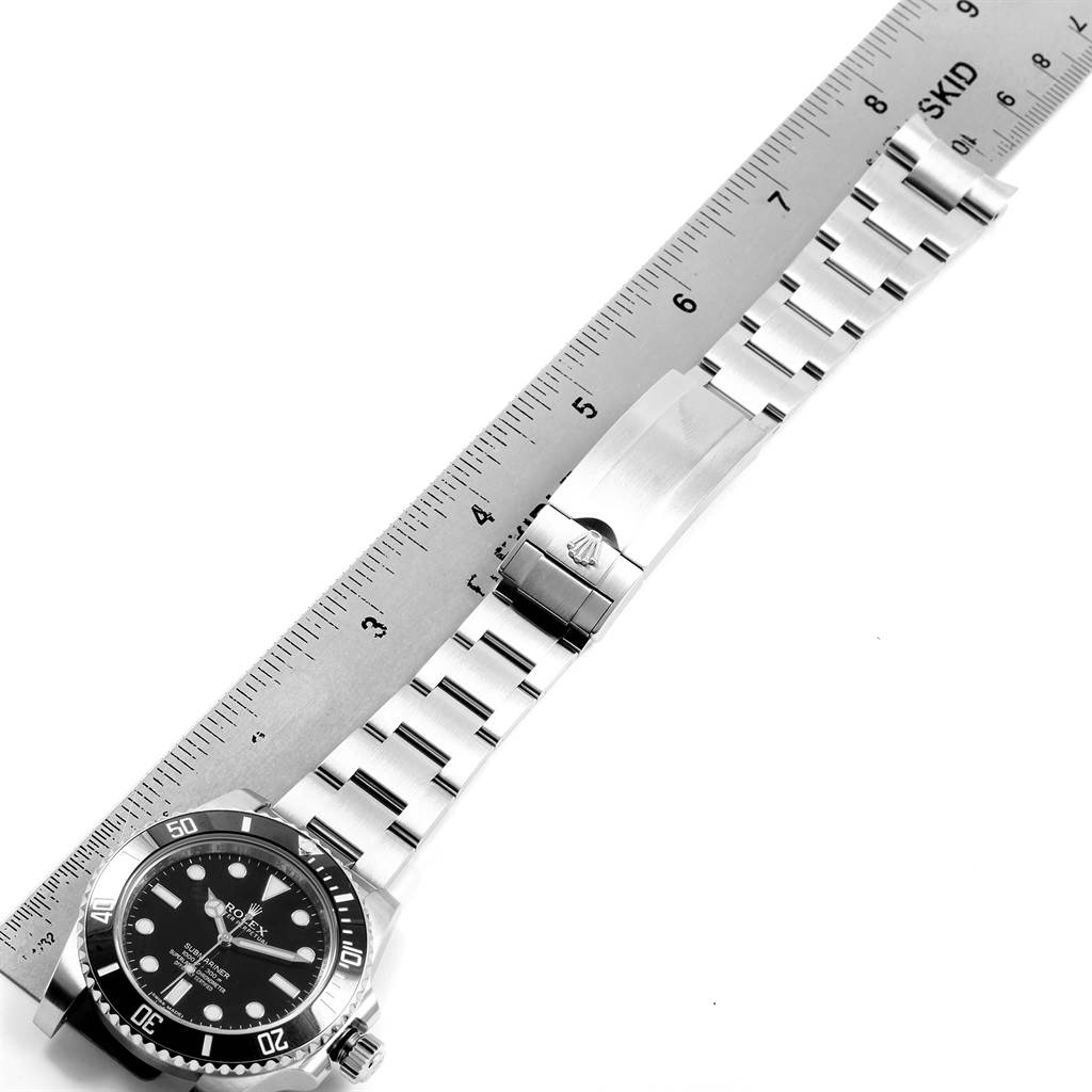 The image shows a side view of a Rolex Submariner 114060 Men's Stainless Steel Black Dial 114060 Men's Stainless Steel Black Dial's face, bracelet, and clasp, with a ruler for scale.