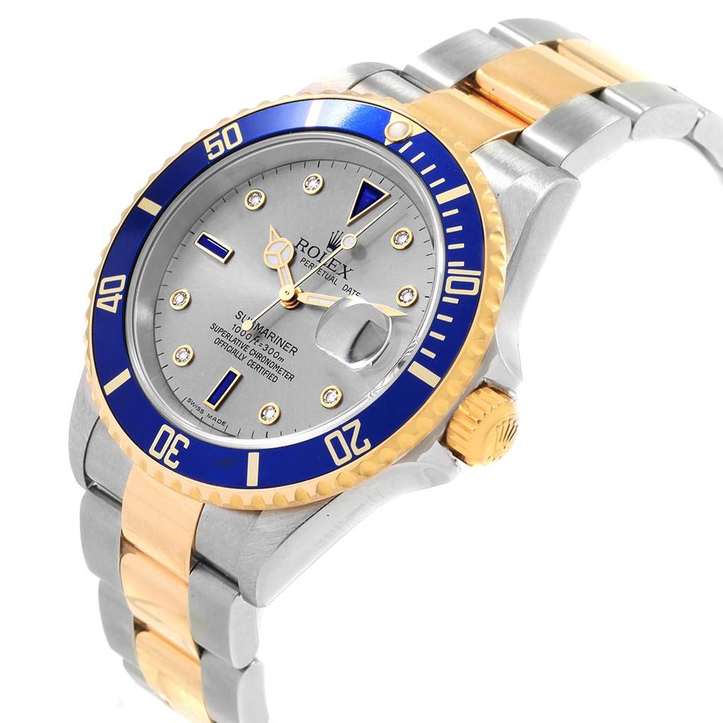 This is a side-angle view of a Rolex Submariner 16613 Men's Steel and Gold (two tone) Grey Dial 16613 Men's Steel and Gold (two tone) Grey Dial, showing its blue bezel, gold and silver bracelet, crown, and part of the dial.