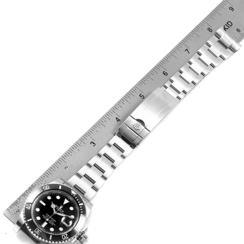This image shows a Rolex Submariner 116610 Men's Stainless Steel Black Dial 116610 Men's Stainless Steel Black Dial watch laid flat with a ruler, displaying the face, bezel, and bracelet including the clasp.