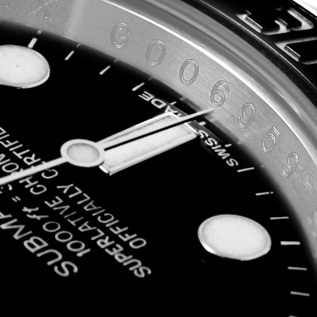This close-up image of a Rolex Submariner 116610 Men's Stainless Steel Black Dial 116610 Men's Stainless Steel Black Dial watch shows the dial, partial indices, and part of the rehaut with engraving.