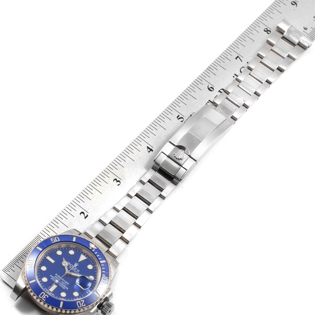 The image shows a top-down view of a Rolex Submariner 116619BLSO Men's White Gold Blue Dial 116619BLSO Men's White Gold Blue Dial watch with its face, bezel, and part of the metallic bracelet against a ruler.